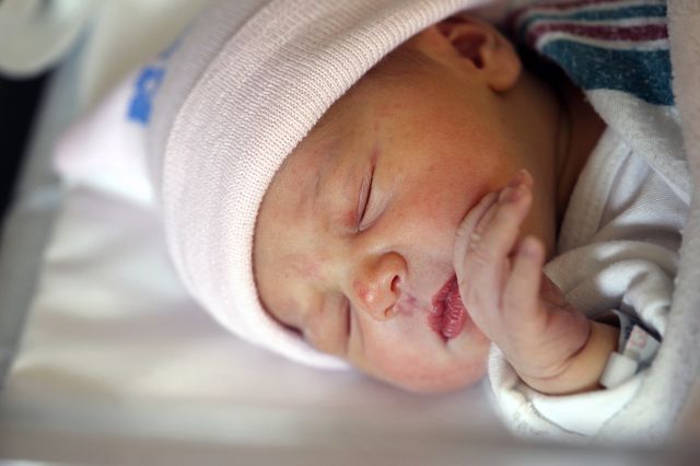 A newborn baby girl after birth in a hospital environment.